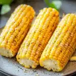 Close-up of air fryer corn on the cob with bright lighting and minimal background