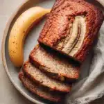 Close-up of low carb banana bread with a golden crust on a minimal background