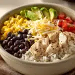 Close-up of a Chicken and Rice Burrito Bowl with fresh ingredients and vibrant colors.