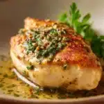 Close-up of a delicious chicken breast meal with creamy sauce and herbs.