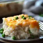 Close-up of chicken rice casserole with creamy sauce and herbs, showcasing appetizing textures.