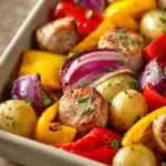 Close-up of chicken sausage with roasted vegetables on a sheet pan, vibrant and appetizing.