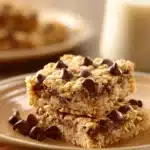 Close-up of chocolate chip oatmeal cookie bars with visible chocolate chips and a golden-brown texture.