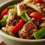 Close-up of Black Pepper Chicken with a creamy sauce and garnished with herbs.