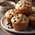 Close-up of freshly baked chocolate chip muffins with a golden brown top.