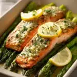 Close-up of garlic butter salmon with lemon asparagus on a white plate