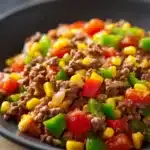 Close-up of a savory ground beef dish with bright lighting and minimal background.