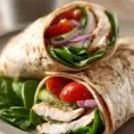 Close-up of a high protein chicken hummus wrap with fresh ingredients