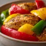 Close-up of Instant Pot chicken and peppers with vibrant colors and minimal background.