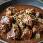 Close-up of keto beef tips and gravy in a crock pot with a rich, hearty appearance.