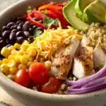 Close-up of a Mexican Chicken Quinoa Bowl with colorful ingredients and a clean background.