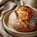 Close-up of freshly baked no knead bread with a golden crust, highlighting its texture and rise.