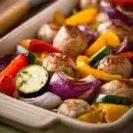 Sheet pan chicken sausage with roasted vegetables on a baking tray