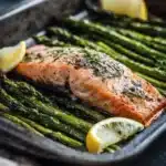 Close-up of roasted salmon and asparagus on a sheet pan with lemon slices