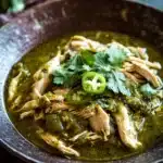 Close-up of slow cooker chicken verde with creamy sauce and herbs