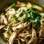 Close-up of slow cooker chicken verde with creamy sauce and herbs