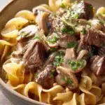 Close-up of slow cooker pot roast stroganoff with creamy sauce and tender beef.
