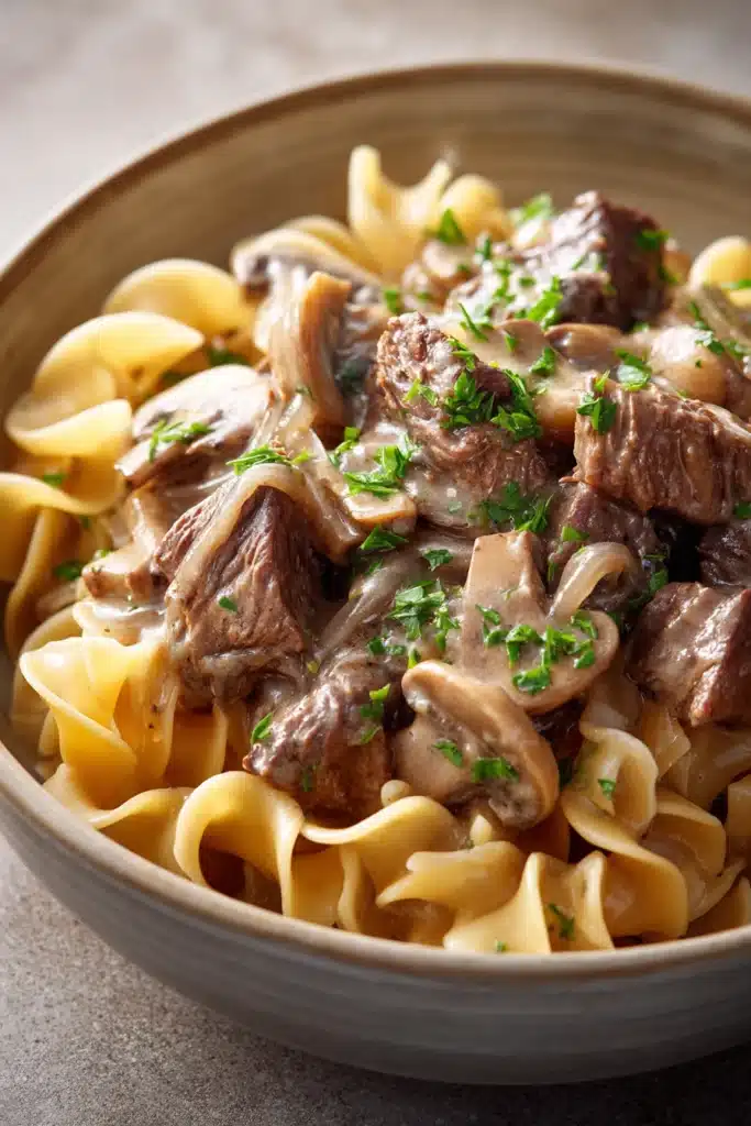 Close-up of slow cooker pot roast stroganoff with creamy sauce and tender beef.