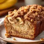 Close-up of banana bread with brown sugar streusel topping, showcasing texture and warmth.