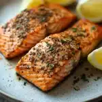 Close-up of air fryer salmon filet with crispy skin and garnished with herbs