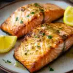 Close-up of air fryer salmon with ginger garnish on a white plate