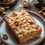 Close-up of banana bread baked oatmeal with a golden crust and warm lighting.