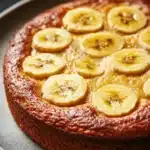 Close-up of a slice of banana cake on a white plate, perfect for kids.