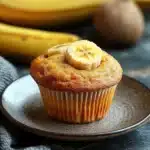 Close-up of freshly baked banana muffins on a wooden surface.