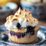 Close-up of a blueberry muffin topped with lemon meringue on a clean background