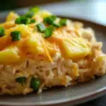 Close-up of a chicken rice pineapple casserole with a golden crust and fresh herbs.
