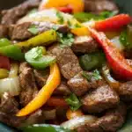 Close-up of crock pot beef pepper steak with vibrant colors and textures