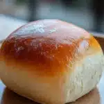 Close-up of freshly baked bread rolls with a golden crust on a clean background.