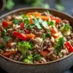 Close-up of a high protein beef and rice bowl with vibrant colors and fresh ingredients.
