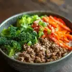 Close-up of a high protein beef and rice bowl with vibrant colors and fresh ingredients.