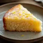 Close-up of a lemon zest cake slice with bright lighting and minimal background