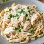 Close-up of low calorie chicken alfredo with creamy sauce and herbs on a white plate