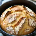 Close-up of a golden crust no knead bread in a cast iron dutch oven