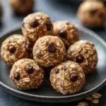 Close-up of oatmeal cookie energy bites on a clean, minimal background with warm lighting.