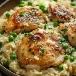 Close-up of a one pot creamy chicken and rice dish with bright, warm lighting.