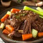 Close-up of a slow cooker pot roast with ranch dressing, showcasing tender meat and herbs.