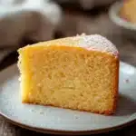 Close-up of a vanilla cake with a smooth, golden-brown crust and minimal background.