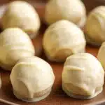 Close-up of a vanilla cake truffle with a smooth, creamy texture on a simple background.
