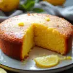 Close-up of a vegan lemon cake with bright, natural lighting and minimal background.
