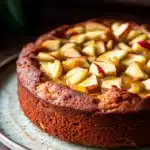 Close-up of a delicious apple cake with applesauce, showcasing its moist texture and golden crust.