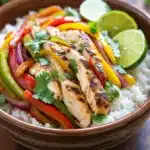 Close-up of sheet pan chicken fajitas rice bowls with colorful vegetables