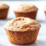 Protein muffin with almond flour - the image shows a group of freshly baked muffins on a white surface. the muffins are golden brown in color and have a crumbly texture on top. they are arranged in a row, with the largest muffin in the foreground and the others in the background. the background is blurred, but it appears to be a kitchen countertop. the overall mood of the image is warm and inviting.